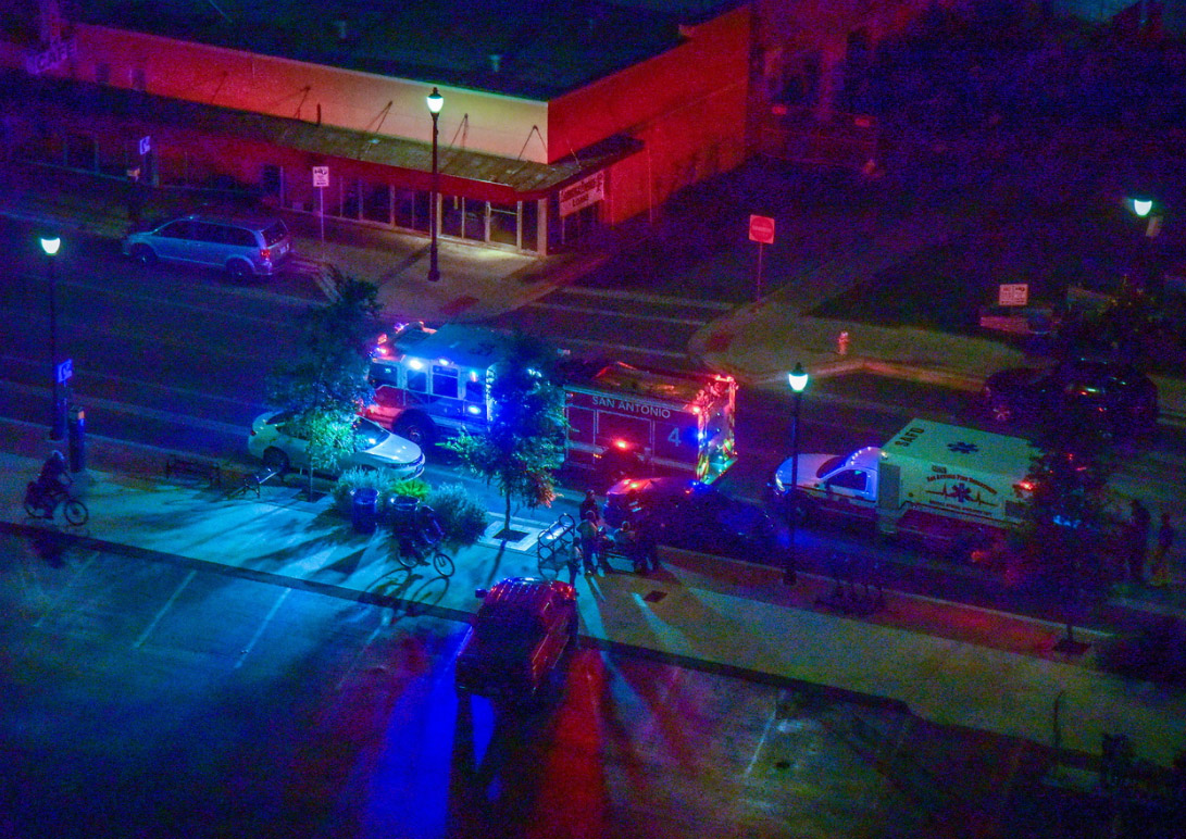 The scene of a traffic crash at night with a firetruck and ambulance present.